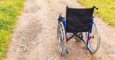 un camino o sendero con piedrecitas pequeñas y una silla de ruedas en el medio