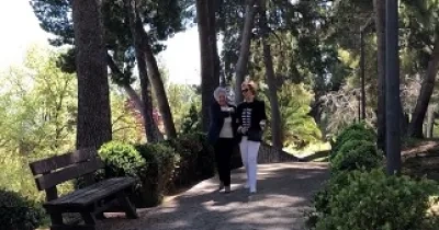 Una persona voluntaria acompaña a otra persona ciega en un paseo (Fuente: ONCE)