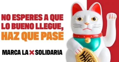 Imagen con fondo blanco y rojo en la que aparece un maneki-neko (gato de la suerte japonés) blanco con detalles rojos, verdes y dorados, levantando una pata. A la izquierda se lee el texto en mayúsculas: “NO ESPERES A QUE LO BUENO LLEGUE, HAZ QUE PASE. MARCA LA X SOLIDARIA”.
