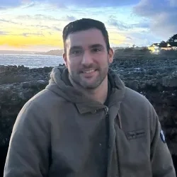 Miguel Rodríguez doctor en una foto personal con un paisaje de playa de fondo