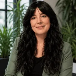 Aima Tafur posando a cámara, con un fondo de unas plantas.