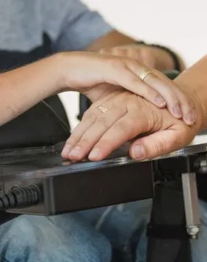 Persona en silla de ruedas junto a cuidadora 