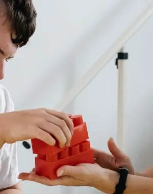 Una psicóloga trabaja con material multisensorial con un joven con discapacidad 