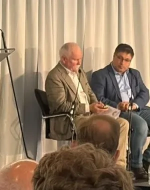 Los ponentes subidos en el escenario del evento, con un moderador en el atril y a su espalda el cartel de AccesibleEU