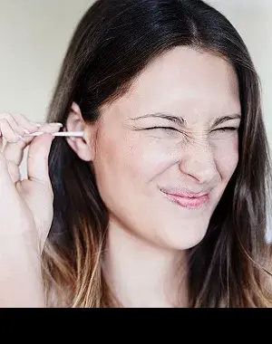 Una persona limpiándose el oído con un bastoncillo (Fuente: Oticon)