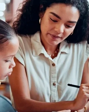 Una mujer con una niña haciendo una tarea