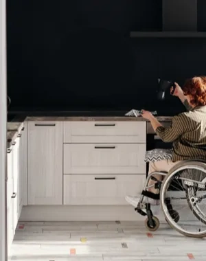 Una mujer en silla de ruedas cocinando en su casa