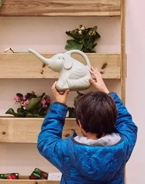 Imagen de un niñp intentando colgar un objeto en una estantería