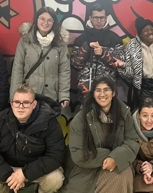 Los quince alumnos posando para una foto delante de un mural
