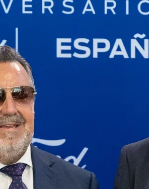 Representantes de Ford España, el Grupo Social ONCE y la Generalitat Valenciana posan durante la presentación del cupón conmemorativo del 50º aniversario de la planta de Ford en Almussafes. En el acto se muestra una reproducción ampliada del cupón dedicado a la inclusión laboral de las personas con discapacidad, con el logotipo del aniversario sobre un fondo azul corporativo de Ford.