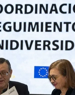 Los representantes de las dos entidades haciendo un acto delante de una pantalla digital donde pone el nombre de la jornada
