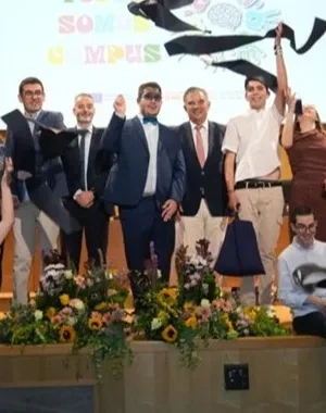 Todos los alumnos graduados posando en el escenario