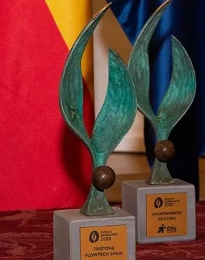 4 premios Zangalleta en la mesa, con bandera de España y Unión Europea de fondo 