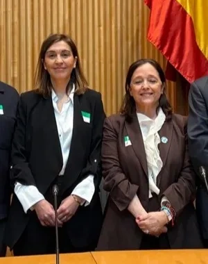 Todos los participantes de la ponencia en la sala del Congreso posando, frente a la bandera de España y de la UE
