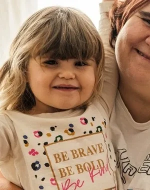 Una mare junto a su hija sentadas en el sofá