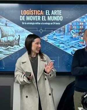 Varios formadores del taller impartiendo indicaciones frente a los alumnos, con el proyector de fondo presentando una diapositiva