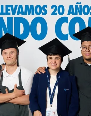 Cinco personas posan juntas frente a un fondo claro vistiendo birretes de graduación. En la parte superior aparece un texto grande en azul: “LLEVAMOS 20 AÑOS CELEBRANDO COMIENZOS”. A la izquierda se lee: “Formamos a personas con discapacidad intelectual para que la graduación sea su primer paso en el mundo laboral”, junto a los logos de Fundación Prodis y la Universidad Autónoma de Madrid. A la derecha hay un código QR con el texto “Ayúdanos a crear más oportunidades”.