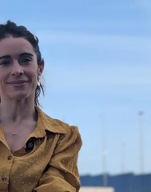 Una de las impulsoras del estudio, posando a cámara sentada en una pista de atletismo y baloncesto de fondo.