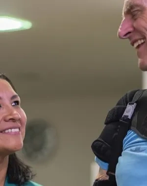 Un señor mayor siendo tratado por una mujer rehabilitadora