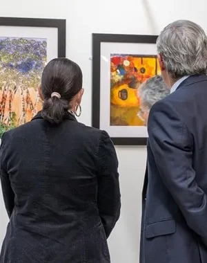 Dos personas observando un cuadro en una exposición