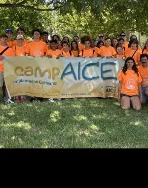 Posado de todos los participantes del campamento, sujetando una bandera con el logo CampAICE
