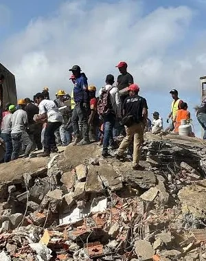 Personas buscando en los escombros y ruinas por el terremoto de Venezuela