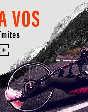 artel promocional del documental Manuela Vos: Derribando límites. En la parte izquierda aparece el título en letras grandes naranjas sobre fondo gris, acompañado del texto “Derribando límites” y un recuadro con la inscripción “INFORME+”. A la derecha, una persona practica ciclismo adaptado en una bicicleta de mano (handbike) sobre una carretera de montaña. El fondo combina una imagen en blanco y negro de montañas nevadas con un recorte en color del paisaje y la carretera. Logo de Movistar+