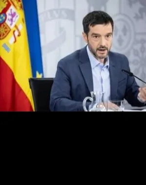 Pablo Bustinduy, Ministro de Derechos Sociales, en una rueda de prensa oficial. Detrás tiene la bandera de la UE y de España