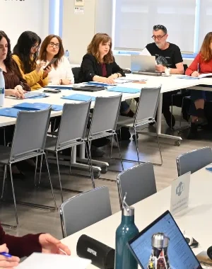 Reunión de los creadores del proyecto en una sala, todos con sus ordenadore
