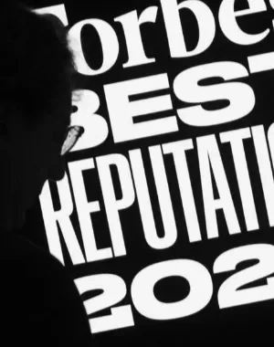 Nombre del evento en blanco sobre fondo negro, se ve también una silueta a la izquierda, del presentador del evento