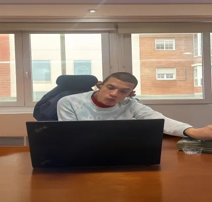 Kenjy trabajando en una oficina con su portatil