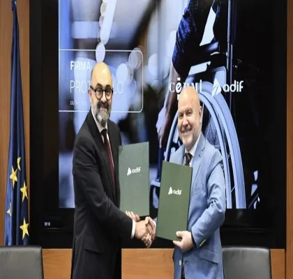 Los dos representantes firmando el acuerdo mientras se dan la mano 