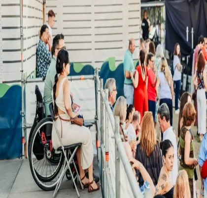 Una mujer en silla de ruedas en un lugar accesible de un evento
