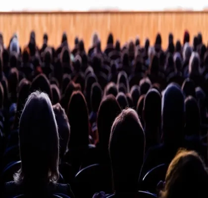 Siluetas de personas de espalda mirando una funcion teatral