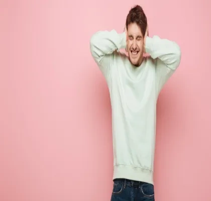 Hombre tapándose los oídos por el ruido tan molesto que escucha