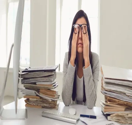 Mujer llevándose las manos a los ojos debido al agotamiento visual del trabajo