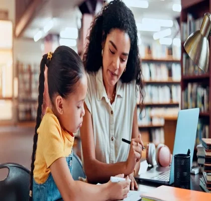 Una mujer con una niña haciendo una tarea