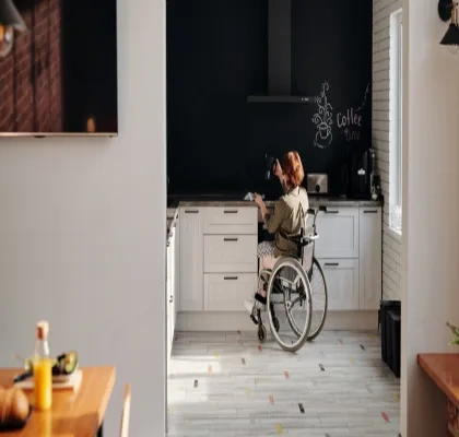 Una mujer en silla de ruedas cocinando en su casa