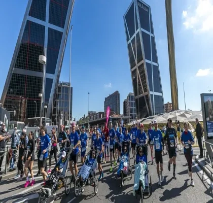 Participantes de la maratón en plena carrera con las Torres de Madrid de fondo