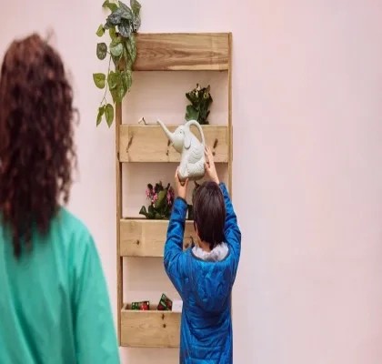 Imagen de un niñp intentando colgar un objeto en una estantería