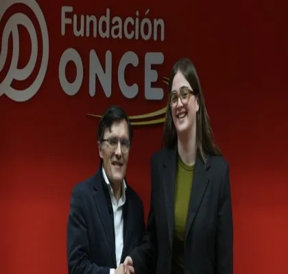 Foto de firma entre Alberto Durán y Andrea González, delante del logo de Fundación ONCE