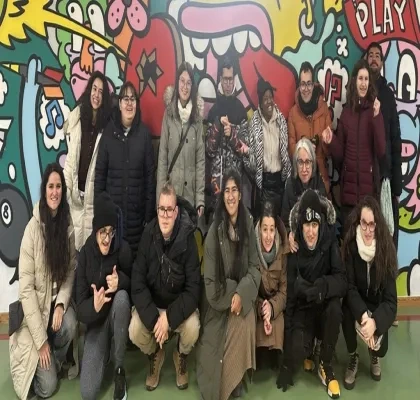 Los quince alumnos posando para una foto delante de un mural