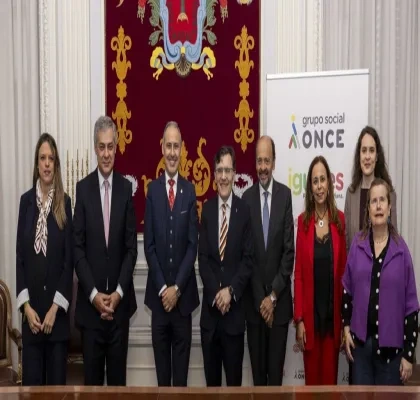 Todos los representantes del acto reunidos con una bandera de fondo