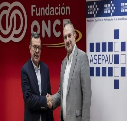 Los dos representantes sellando el acuerdo frente a los logos de las empresa