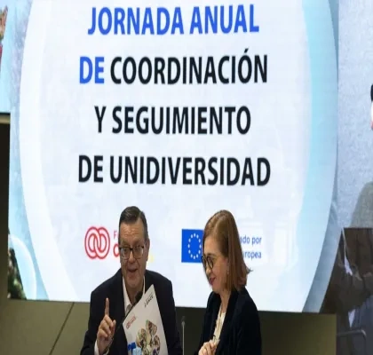 Los representantes de las dos entidades haciendo un acto delante de una pantalla digital donde pone el nombre de la jornada