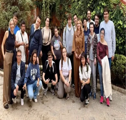 Los 15 alumnos posando en el jardín del campus para una foto grupal