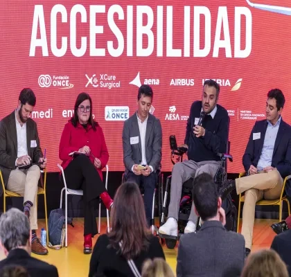 aparecen cinco personas hablando en una charla con un cartel detras que pone accesibilidad