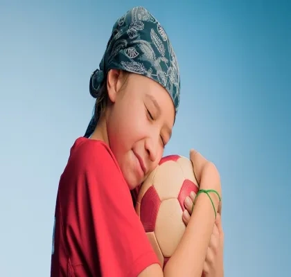Niño con cáncer infantil jugando con una pelota