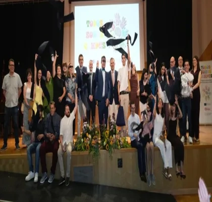 Todos los alumnos graduados posando en el escenario