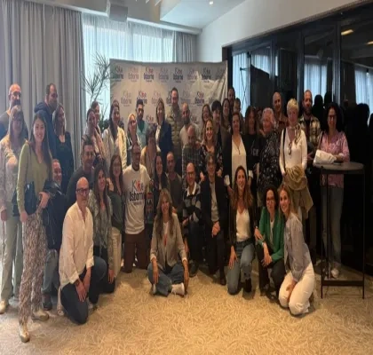 Foto de grupo de familias, profesionales y personas con discapacidad reunidas en una sala, posando juntas tras el taller “Adolescencia, familia y discapacidad” de la Fundación Kike Osborne en Valencia, con un photocall de la Fundación al fondo.